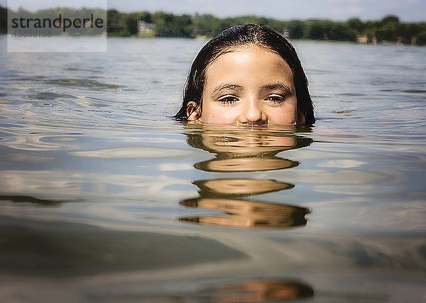 Junges Mädchen in einem See mit nur der oberen Hälfte des Kopfes aus dem Wasser