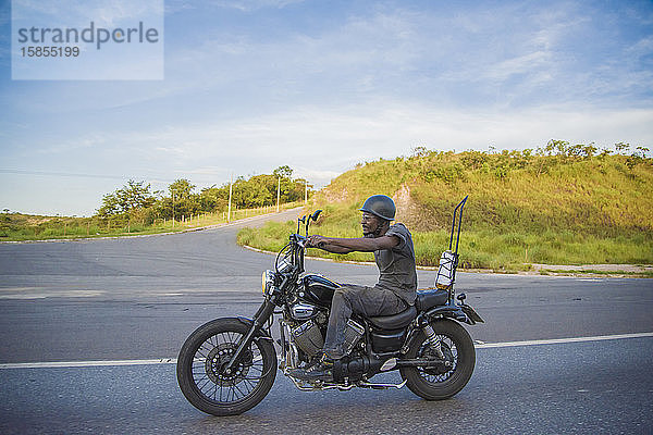 Afrolateinischer Mann fährt Motorrad in brasilianischer Landschaft