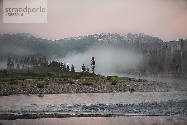 Nebel steigt über dem Upper Snake River im John D. Rockefeller Jr. Memorial Parkway mit den Teton Mountains im Hintergrund auf