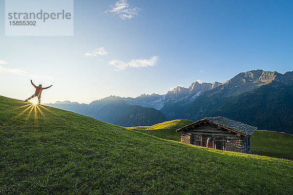 Rückansicht eines in der Morgendämmerung jubelnden Mannes  Tombal  Soglio  Schweiz