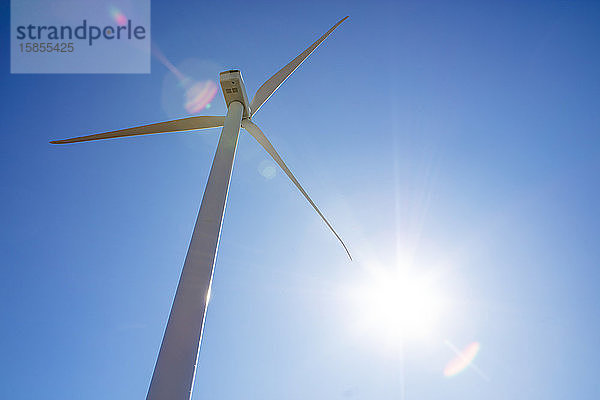 Windturbine gegen blauen Himmel mit Sonneneruption