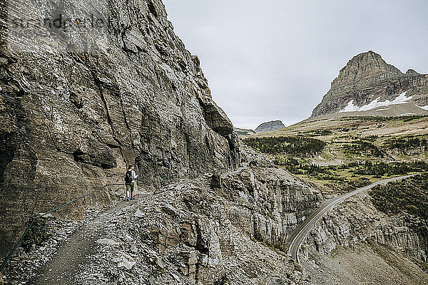 Wanderin wandert am Rande einer Klippe entlang  Highline Trail  Montana