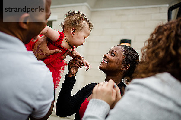 Afroamerikanische Stiefschwester lächelt Biracial-Baby-Schwester an