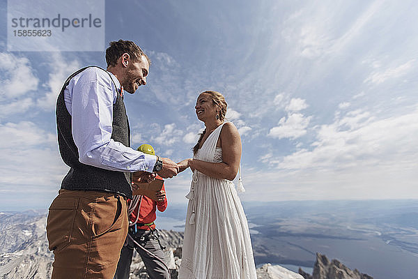 Ehepaar tauscht während der Hochzeit auf dem Gipfel des Berges Gelübde und Ringe