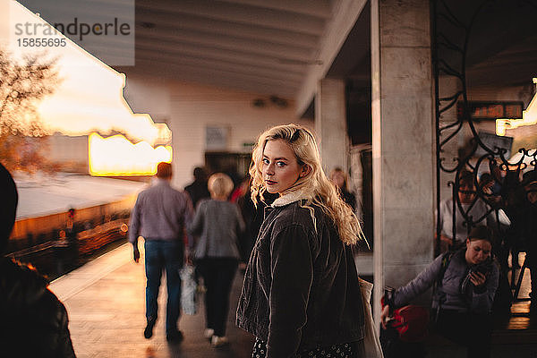 Junge Frau schaut zurück in die Kamera und geht in der U-Bahn-Station