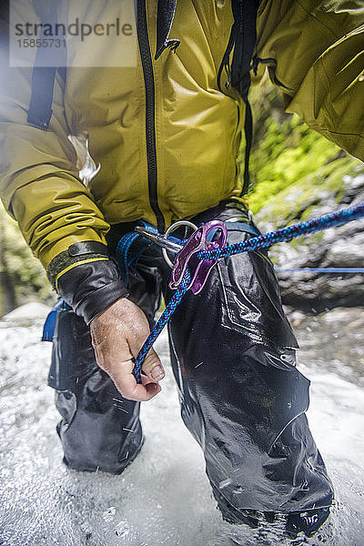 Nahaufnahme eines Mannes mit Sicherungsgerät beim Canyoning.