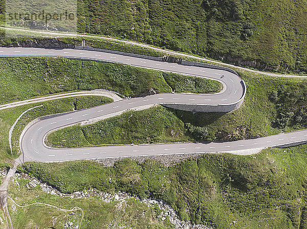 Vogelperspektive auf einen Radfahrer  der eine kurvige Schweizer Autobahn hinunterrast