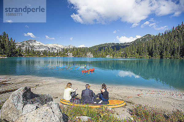 Familie entspannt gemeinsam am abgelegenen See  Bruder paddelt auf dem See.