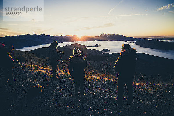 Fotografen bei Sonnenaufgang auf dem Gipfel des Berges