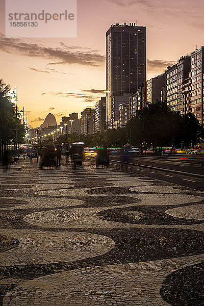 Schöne Aussicht auf den Sonnenuntergang auf den Spaziergang und die Gebäude am Copacabana-Strand