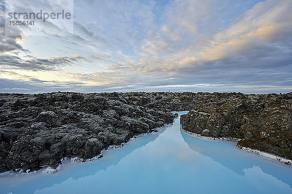 Malerische Landschaft mit bewölktem Himmel über blauer Lagune bei Sonnenuntergang