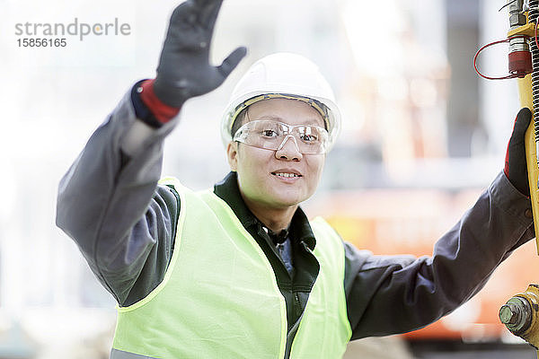 Bauingenieur  der vor einem Bagger steht