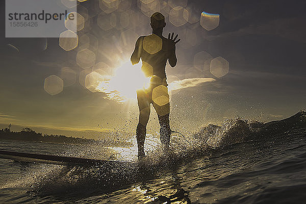 Silhouette eines Surfers bei Sonnenuntergang