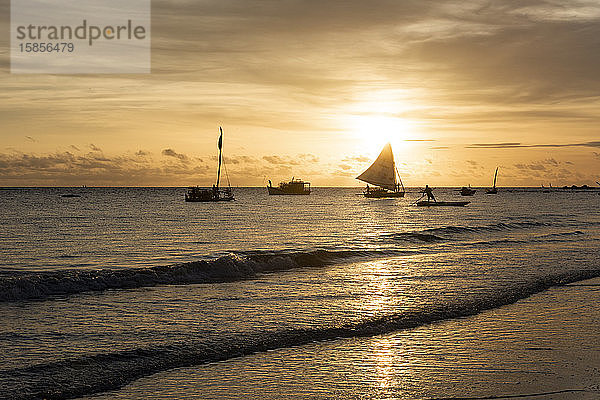 Fischer auf Boot während des Sonnenaufgangs am Praia da Redonda