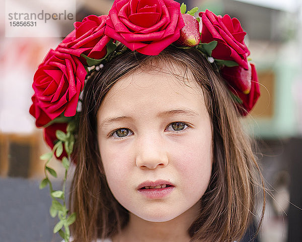 Bildnis eines ernsten kleinen Mädchens mit einem Rosenkranz im Haar