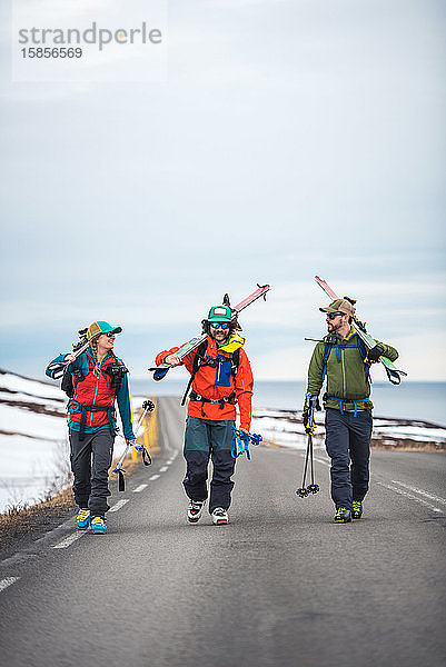 Drei Personen auf einer gepflasterten Straße in Island
