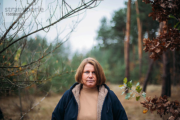 Nahaufnahme-Porträt einer im Wald stehenden Frau