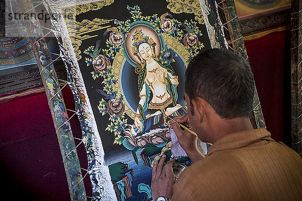 Ein nepalesischer Künstler beendet ein Gemälde in einer Werkstatt in der Nähe von Bhaktapur