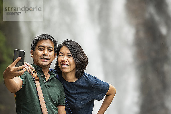 Ehepaar macht sich mit ihrem Smartphone am Ramboda-Wasserfall ein Selfie