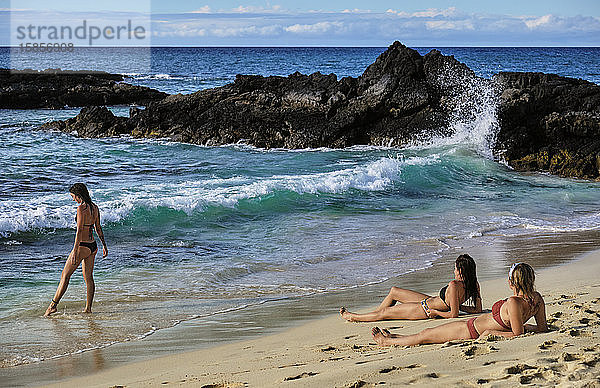 Drei Freunde genießen die Wellen und den Sand am Makalawena Beach  Hawaii