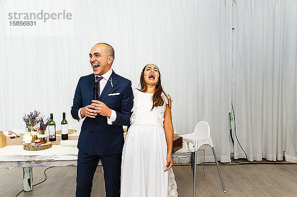 Aufgeregtes Brautpaar lacht während der Hochzeitsrede
