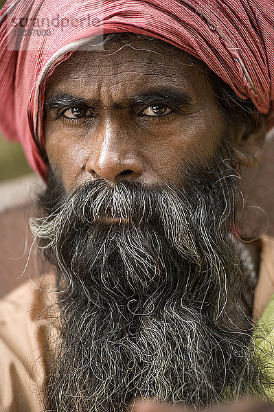 Religiöser Mann mit langem Bart und rotem Turban