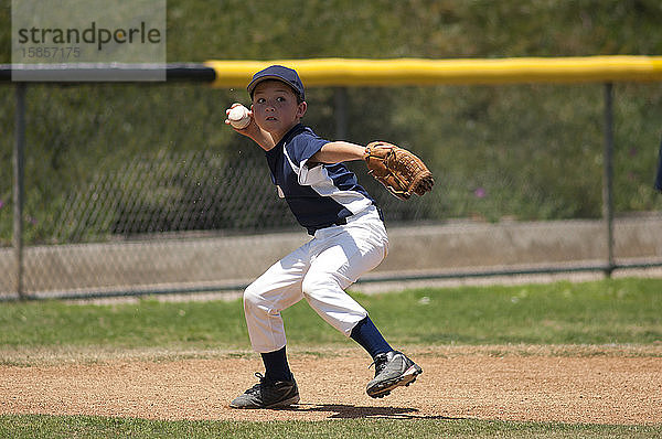 Little League-Baseball-Infielder bereit zum Wurf auf die erste Base