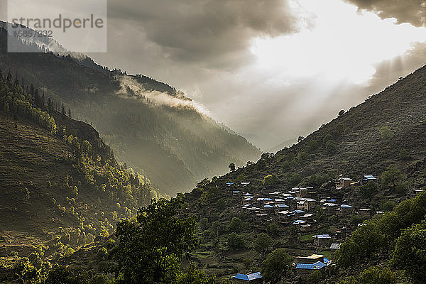 Landschaft mit grünem Bergtal und Dorf bei Sonnenuntergang in Nepal