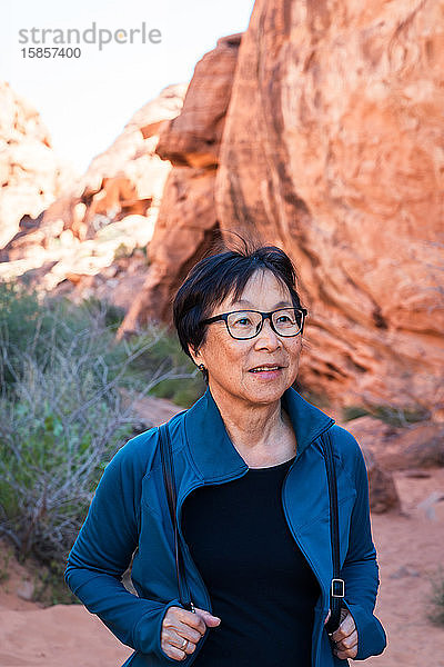 Porträt einer älteren asiatischen Frau  die in der Wüstenlandschaft wandert