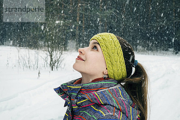 Mädchen schaut Schneeflocken an und lächelt