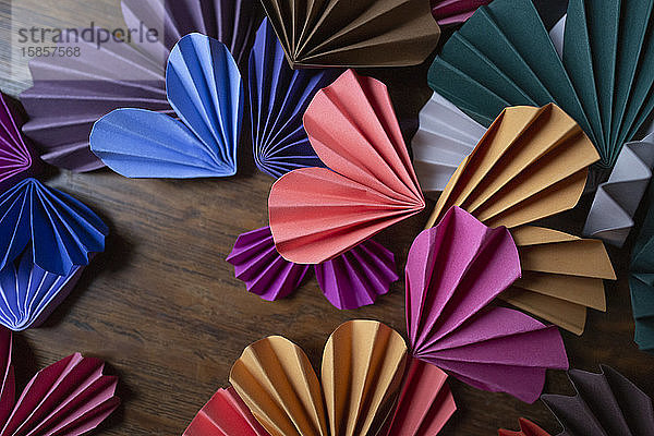 Mehrfarbige Papierherzen auf Holzoberfläche zum Valentinstag