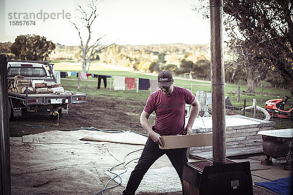 junger männlicher Bauer mit Mütze arbeitet im australischen Farmschuppen