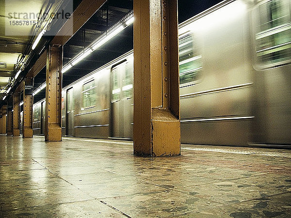 Innenansicht der U-Bahn  die durch die Station in NYC fährt