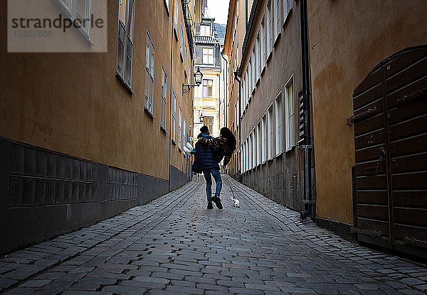 Mann trägt seine Freundin verliebt auf einer europäischen Straße