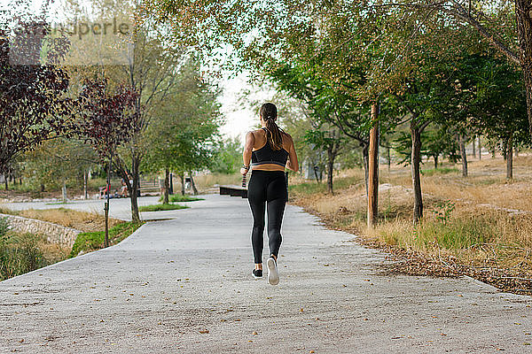 Junge Frau läuft in einem Stadtpark. Weibliche Athletin  Sportkonzept.