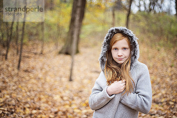 Junges rothaariges Mädchen im Pullover im Herbst draußen.