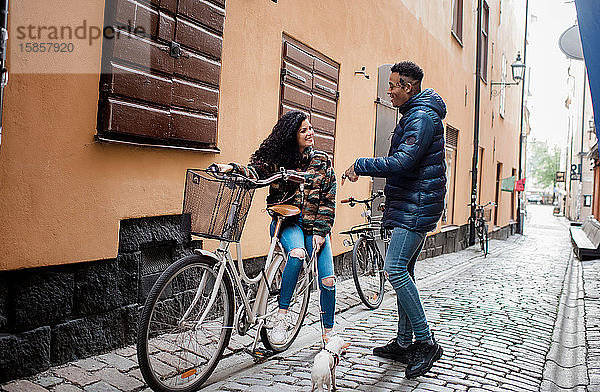 Mann und Frau auf den Straßen in Europa saßen auf einem Fahrrad und unterhielten sich