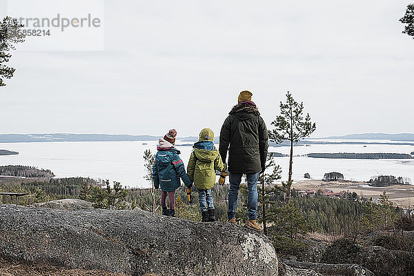 Vater und seine Kinder genießen eine schöne Küstenlandschaft in Schweden