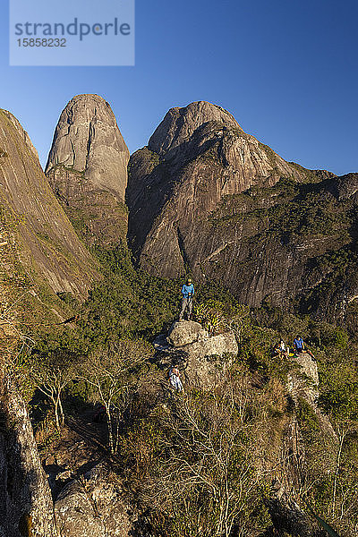 Trekking-Menschen auf felsigem Gipfel in der Nähe von Bergen im Regenwald
