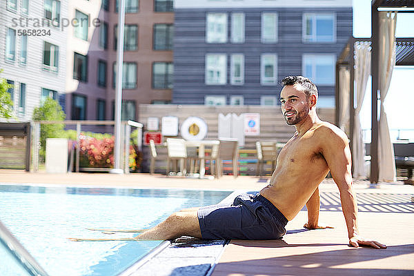 Ein Mann entspannt sich am Pool.