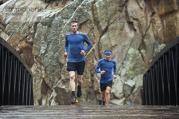 Männerpfad läuft bei Regen über die Bachbrücke im Boulder Canyon  Colorado