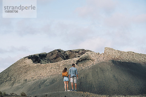 Ehepaar beim Blick auf den Vulkan Cuervo auf Lanzarote  Timanfaya.