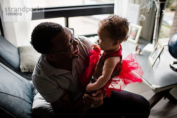 Afroamerikanischer Vater lächelt Biracial-Tochter an
