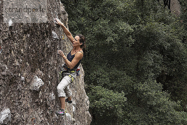 Eine Frau hält sich beim Felsklettern in Jilotepec konzentriert