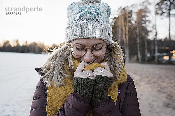 Porträt einer warm eingepackten Frau am Strand in Schweden