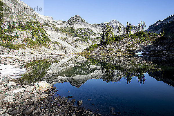 Panoramablick auf einen Berggipfel und seine Spiegelung auf einem See.