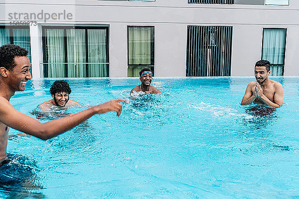 Junge Leute machen Witze in einem umzäunten Pool