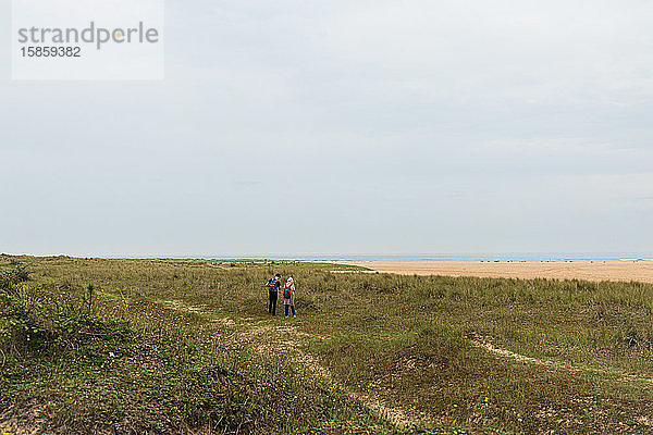 2 Menschen zu Fuß entlang der Küste von Norfolk