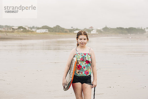 Nahaufnahme eines jungen Mädchens  das ein Boogie-Board am Strand hält