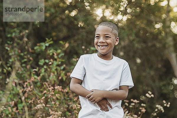 Nah uo Porträt eines jungen  selbstbewussten Jungen im Schulalter  der draußen lächelt